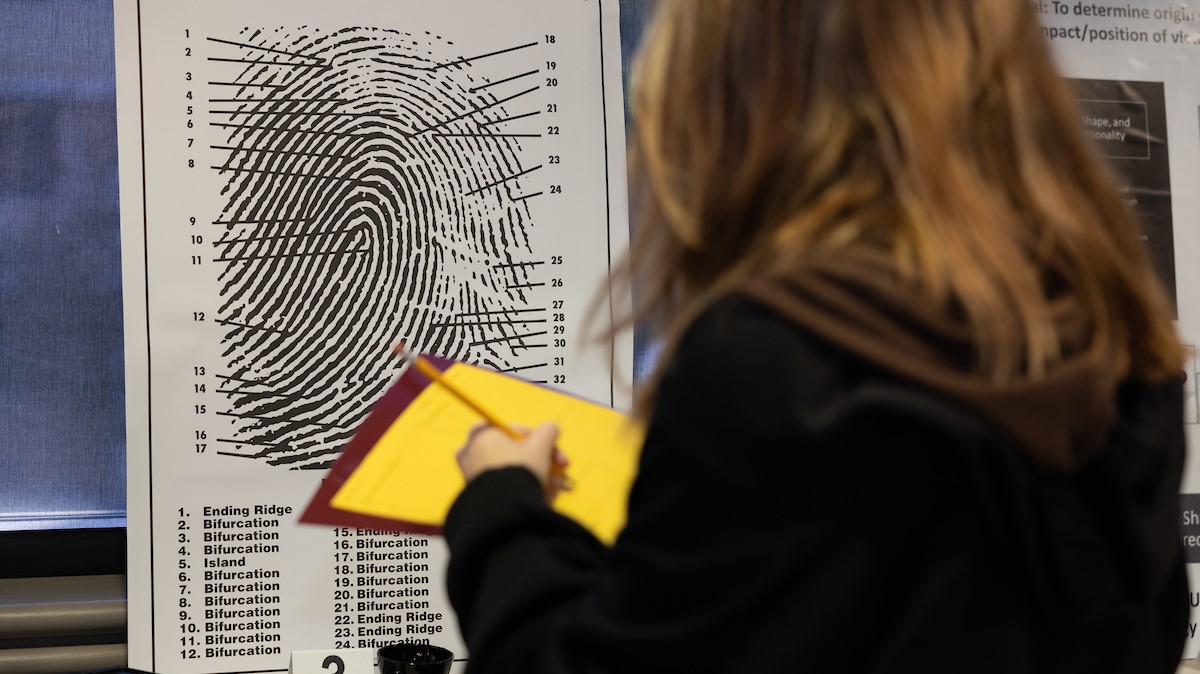 A Missouri State student investigates a fingerprint diagram.