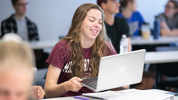 Student getting ready to use laptop in class. 