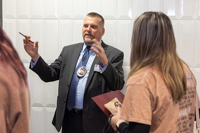 Criminology assistant professor Michael Kyle talks to a student during an open house event