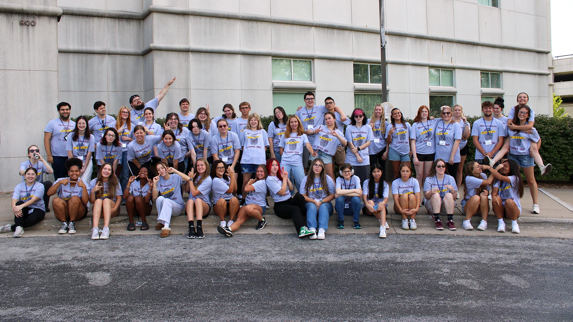 Large group of students pose outside in the Strong Hall building at Missouri State University