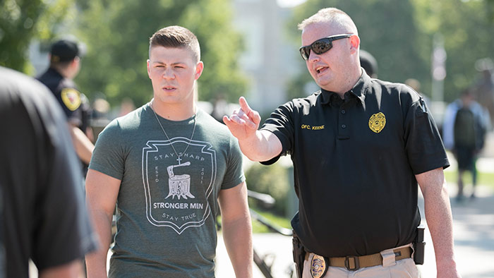 Police officer talking to student during Cops on Campus event.